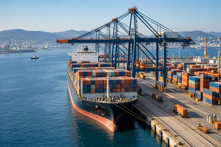 Container ship beside port cranes